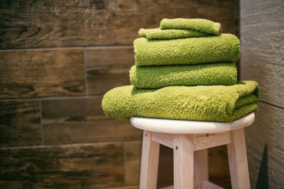 Folded textured towels on a wooden stool