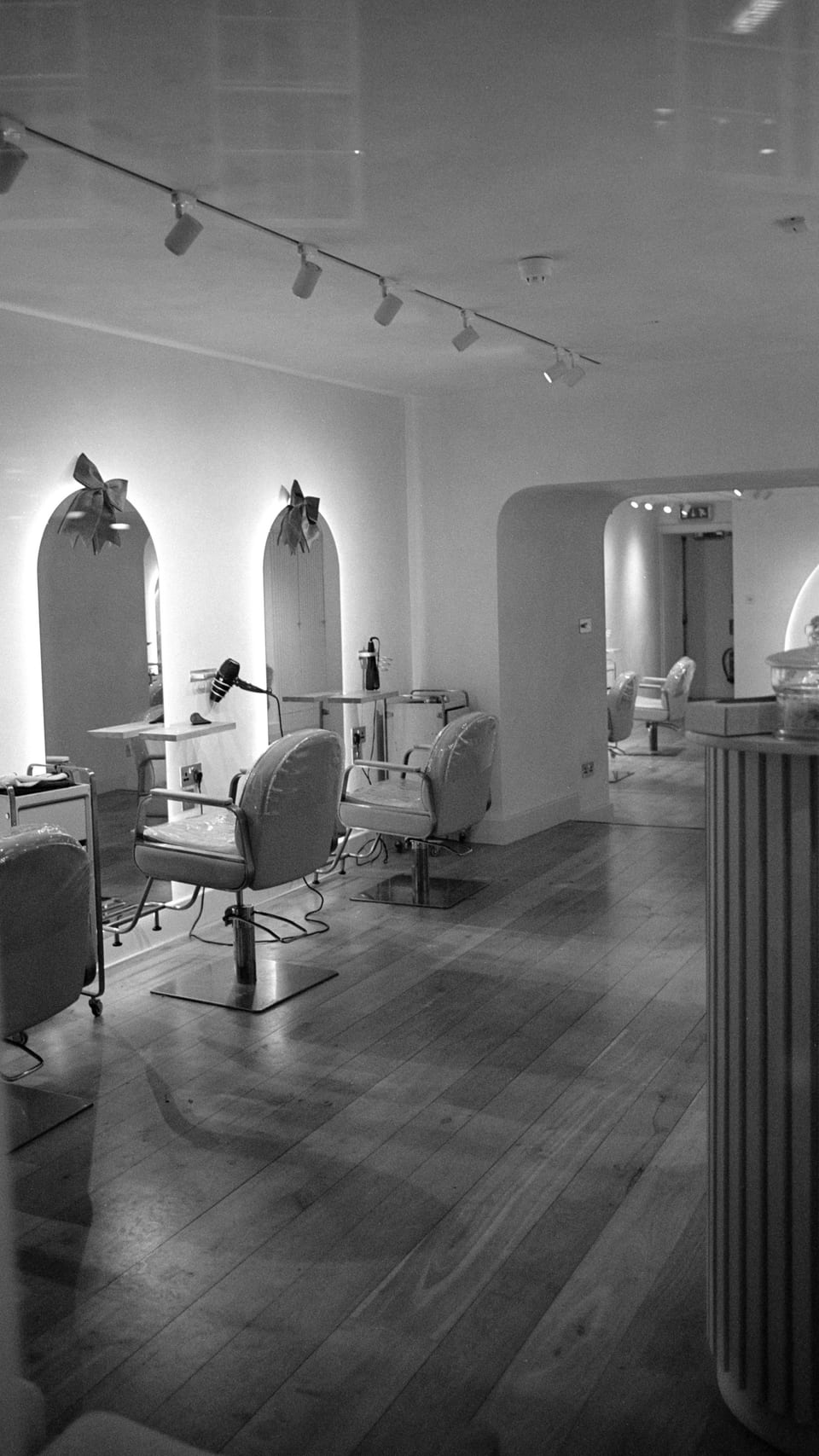 Arched mirrors and chairs in a light-filled salon